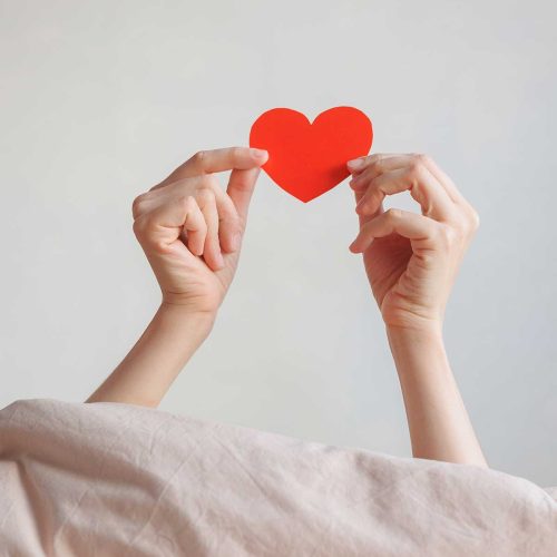 Hands holding red heart. Gift Card idea for love, romance, or Valentine's Day.